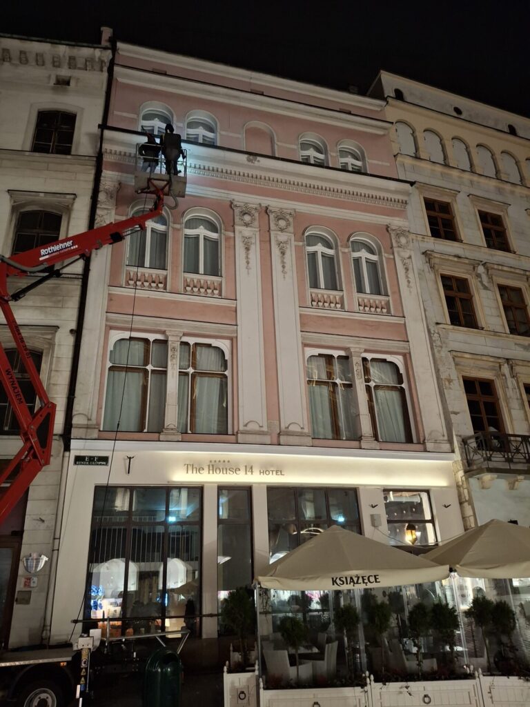 Czyszczenie zabytkowej elewacji hotelu na Rynku Głównym w Krakowie, praca z podnośnika koszowego
